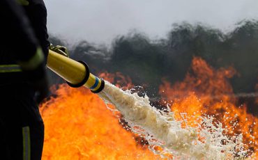 Fire-fighters applying foam to a fire.